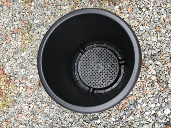 空のプラスチックの黒い鉢の底が網になっている